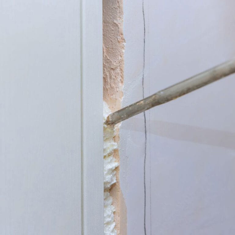 Espuma PU A1 de Topsen aplicada para sellar los huecos entre un marco de puerta y una pared, proporcionando aislamiento y sellado hermético.